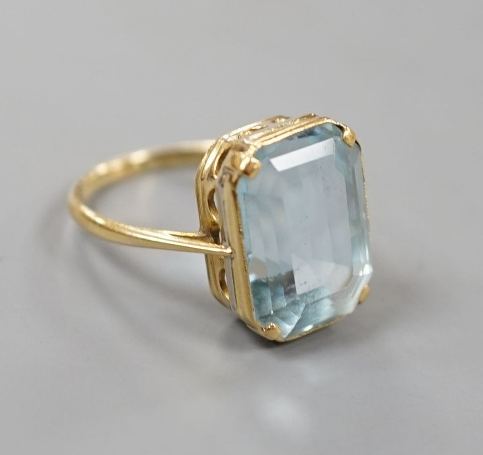 A yellow metal and single stone emerald cut aquamarine set dress ring, size K/L, gross 5.8 grams.